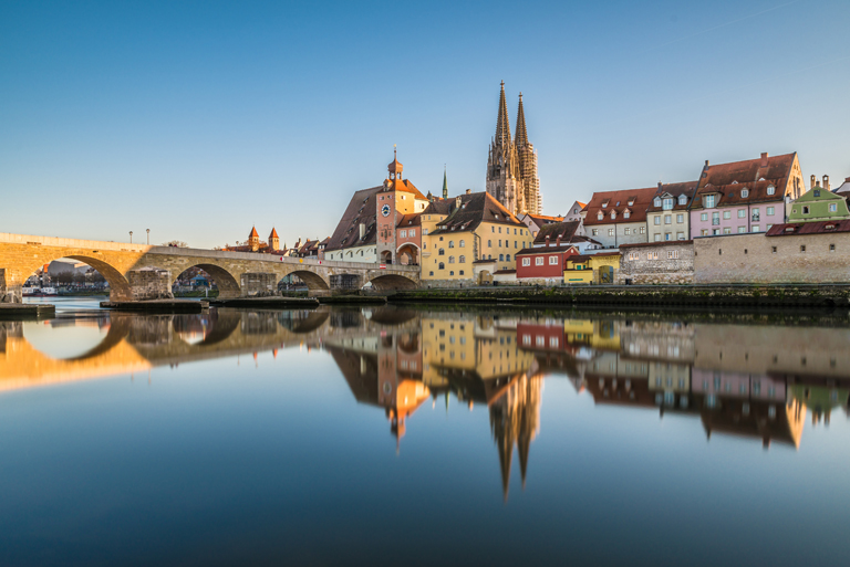 Aussicht über die Donau auf die Regensburger Steinerne Brücke und den Dom zur blauen Stunde