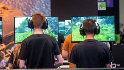 Besucher auf der gamescom 2026 in Köln testen neue Videospiele an mehreren Gaming-Stationen.