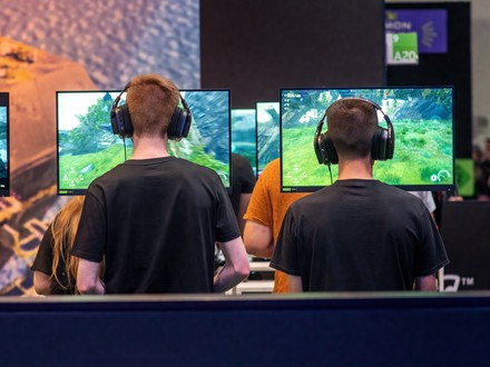 Besucher auf der gamescom 2026 in Köln testen neue Videospiele an mehreren Gaming-Stationen.