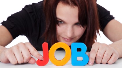 Mädchen bildet das Wort Job aus bunten Buchstaben.