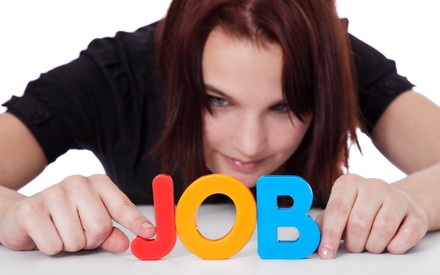 Mädchen bildet das Wort Job aus bunten Buchstaben.