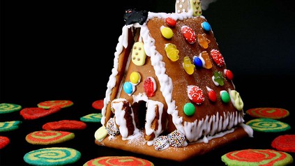Buntes, modernes Lebkuchenhaus geschmückt mit bunten Gummibärchen und Smarties.