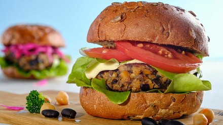 Bild von Burger mit Tomaten und Käse, Seitenansicht.