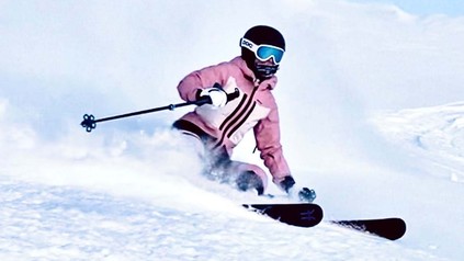Junges Mädchen, das neben der Piste im Pulverschnee fährt.