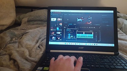 Schnittarbeit für den Videoessay-Wettbewerb zuhause auf dem Sofa mit Laptop auf dem Schoß.