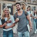 Mehrere Studierende mit Rucksäcken und Ordnern vor der Universität.