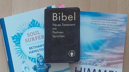 Auf einem Tisch sind Bücher und die Bibel zu sehen.