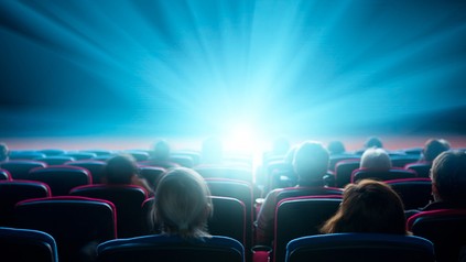 Menschen im Kinosaal, Rückansicht auf Licht der Leinwand.