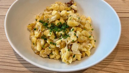 Käsespätzle auf einem Teller mit Schnittlauch angerichtet.