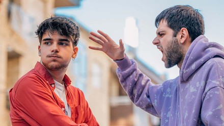 Zwei junge Männer, die sich draußen streiten.