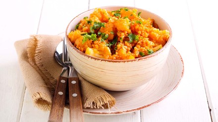 Curry in einem Schälchen mit Unterteller auf dem Tisch.