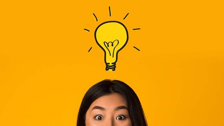 Auch mentaler Sport kann anstrengend sein. (Foto: © stock.adobe.com/Prostock-studio) Verwunderte junge Frau mit leuchtender Glühbirne über dem Kopf.