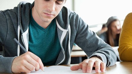 Junger Student beim Einstufungstest sitzend.
