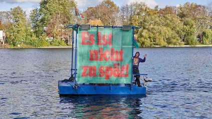 Klimaplakat auf schwimmendem Untersatz im Wasser.