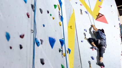 Frau bei Klettern an Kletterwand.