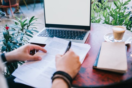 Wie kannst du dich in deinem Lebenslauf bestmöglich darstellen? (Foto: © stock.adobe.com/BullRun) Arbeitsplatz mit aufgeklapptem Laptop und Kaffee draußen.