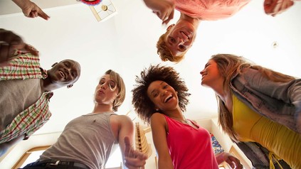 Internationale Studierende, die lachen und um Kamera stehen.