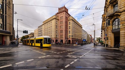 Berlin Mitte mit Tram, die über eine Kreuzung fährt.