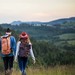 Zwei Studenten beim Wandern mit Aussicht auf die Berge, die vor ihnen liegen.