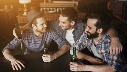 Drei Kumpels beim Biertrinken in einer Bar.