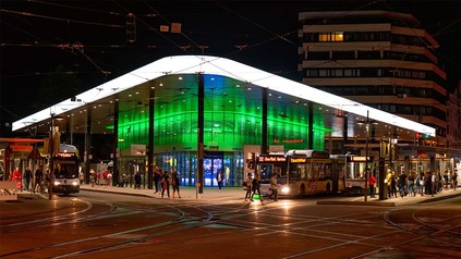 Sicht auf die Bahnsteige des Königsplatzes in Augsburg, abends mit grüner Beleuchtung.