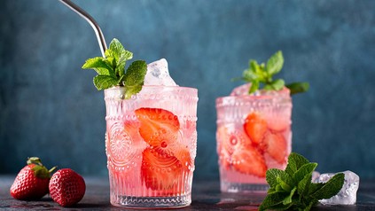 Zwei schön mit Mustern verzierte Gläser Erdbeer-Mojito mit Minze angerichtet.