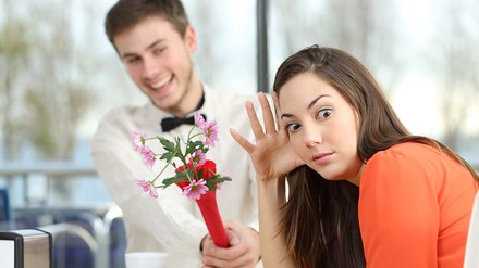 Da hat wohl einen der Ick getroffen: Blumen beim ersten Date – wie peinlich? (Foto: © Antonioguillem/stock.adobe.com) Ein Mann in weißem Hemd überreicht einer Frau in orangenem Pulli Blumen beim Date. Die Frau wendet sich mit entgeistertem Blick ab.
