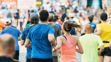 Mehrere Läufer bei einem Stadtlauf, die von hinten abgelichtet wurden.
