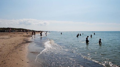 Aufnahme von einem Sandstrand mit Badegästen an Dänemarks Küste.