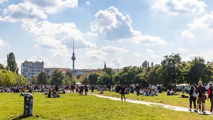 Junge Menschen an wolkigem Sommertag im Mauerpark Berlin.