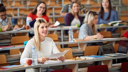 Studierende sitzen im Hörsaal und verfolgen mit großer Neugier eine Vorlesung.