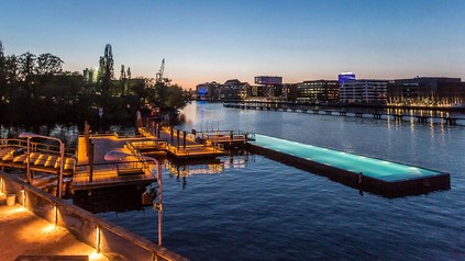 Bild vom Badeschiff Berlin inklusive Sonnendeck und Sicht auf die Spree bei Nacht.
