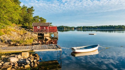 Küste vor Stockholm, Blick auf Bootshütte mit Boot.