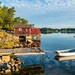 Küste vor Stockholm, Blick auf Bootshütte mit Boot.