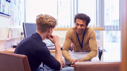 Junger Student mit Mitarbeiter von Uni-Beratungsstelle im Gespräch.
