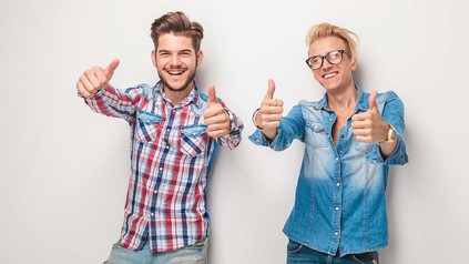 Zwei junge Männer im Hemd, die jeweils beide Daumen nach oben halten.
