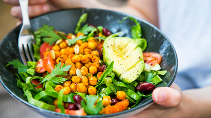 Vegane Bowl mit Avocado in Tonschale.