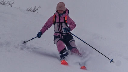Alena beim Skifahren in rosa-farbener Skimontur.