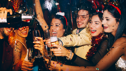 Gruppe junger Leute mit Sektgläsern auf einer Silvesterparty.