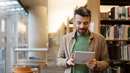 Junge Mann in einer Bibliothek (Foto: © Adobe Stock/ Maria Vitkovska)