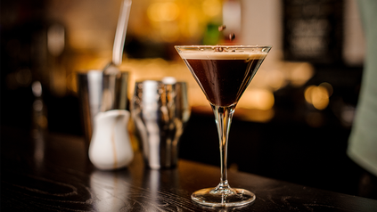 Aufnahme von Espresso Martini in Martini-Glas auf Holztheke.