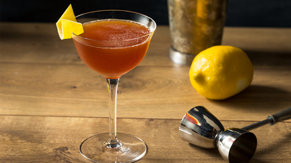Paper Plane in Martini-Glas auf Holztresen.