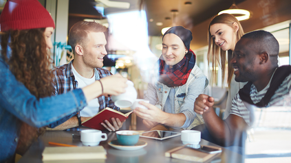 5 junge Menschen zusammen bei einem Gespräch im Café.