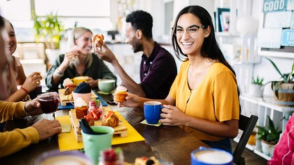 Junge Menschen verschiedener Ethnien beim gemeinsamen Essen von Gebäck. (Foto: © stock.adobe.com/Xavier Lorenzo)
