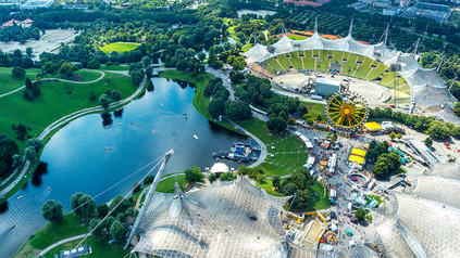 Sicht auf den Olympiapark und den Olympiasee in München von oben.