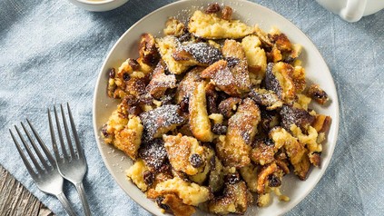 Kaiserschmarrn in Teller auf hellblauem Tischtuch.