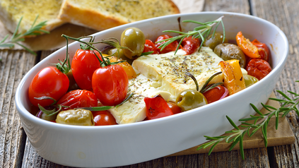 Gebackener Feta mit Tomaten und Oliven in Ofenschälchen.