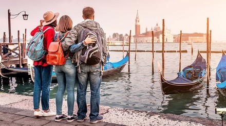 Auslandsstudierende in Venedig Arm in Arm vor einem Anlegeplatz.