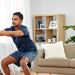 Junger Mann daheim im Wohnzimmer beim Home Workout.