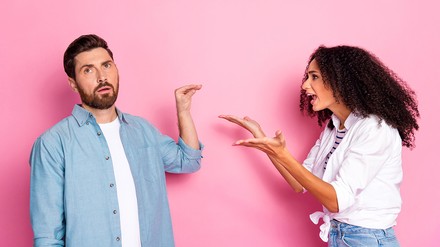 Pärchen beim Streit. Sie hebt gestikulierend die Arme, er währt mit eine Handbewegung ab.